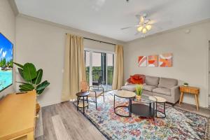 a living room with a couch and a table at 2BR Condo with pool, near Disney! in Orlando