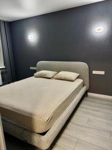 a bed in a bedroom with two pillows on it at Простора і сучасна євродвушка в центрі Черкас! in Cherkasy