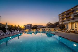 een groot zwembad met stoelen en een gebouw bij Apartments Top Hill in Trogir +71 foto's