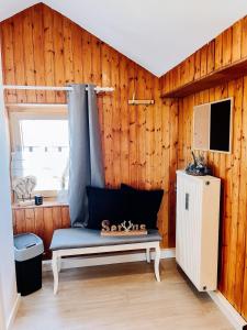 ヴィヒタッハにあるApartment Viechtachの木製の壁の前にベンチ付きの部屋