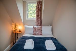 a small bedroom with a bed with a window at Hazel House - Cosy 2 bedroom house with parking near to Oxford in Oxford