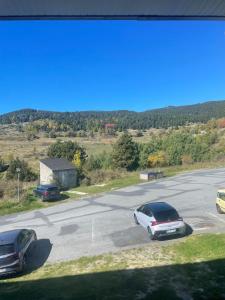 - une vue sur deux voitures garées sur un parking dans l'établissement Carols cosy, à Font-Romeu-Odeillo-Via