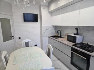 a white kitchen with a table and a microwave at Транзит Сервис 1 Аэропорт- Кишинёв in Chişinău +44 photos