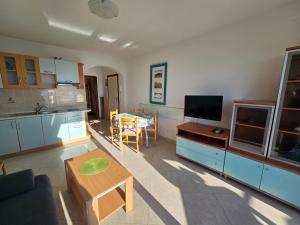a living room with a table and a kitchen at Apartmani Vanessa in Dramalj