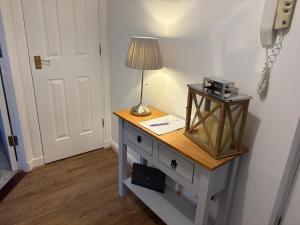 a room with a desk with a lamp and a door at Kinfirth Apartment in Ayr