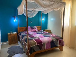 a bedroom with a bed with a canopy at maison rio la rufisquoise in Saly Portudal