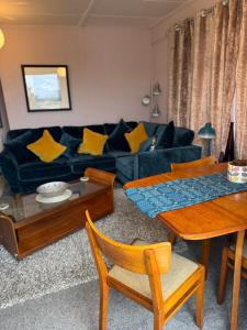 a living room with a blue couch and a table at Coastal Cabin Chalet in Roch