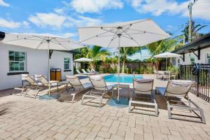 a patio with chairs and umbrellas next to a pool at Haley's at Anna Maria Island Inn in Holmes Beach