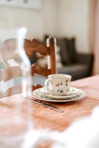een kopje op een tafel met een bord erop bij Gîte de la maraîchère in Ittre