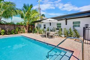 a swimming pool with an umbrella next to a house at Haley's at Anna Maria Island Inn in Holmes Beach