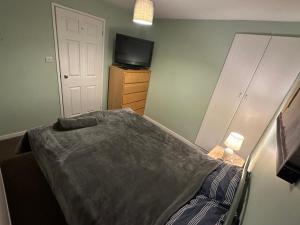 Un pequeño dormitorio con una cama y un televisor. en Newport by M4, en Newport