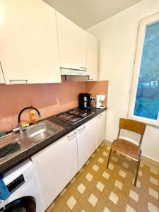 a kitchen with a sink and a stove top oven at Maison Bon Séjour in Livry-Gargan