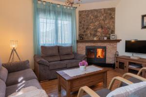 een woonkamer met een bank en een open haard bij Casas Rurales La Loma in Riópar