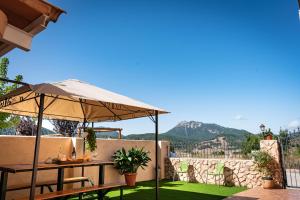 een patio met een parasol en een tafel op een gazon bij Casas Rurales La Loma in Riópar