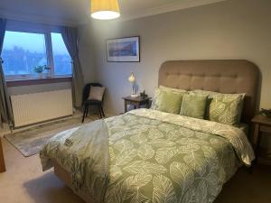 a bedroom with a large bed and a window at The Place in Johnshaven