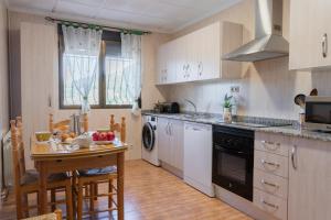 een keuken met witte kasten en een tafel met fruit erop bij Casas Rurales La Loma in Riópar