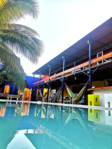 a building with a swimming pool with hammocks in it at Hotel Chuburna in Chuburná