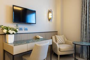 a hotel room with a desk and a chair and a tv at Abacus Hotel in Sesto San Giovanni