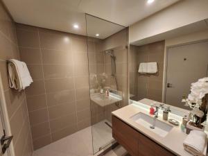 a bathroom with a shower and a sink and a mirror at Elite 2BR Abode Distinctive Living at The Shores in Manama +34 photos