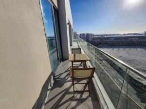 a balcony with two chairs and a table on a building at Elite 2BR Abode Distinctive Living at The Shores in Manama