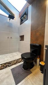 a bathroom with a black toilet in a room at The Valley Cabin in Alfredo Wagner
