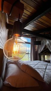 a large glass light hanging from a room with a bed at The Valley Cabin in Alfredo Wagner