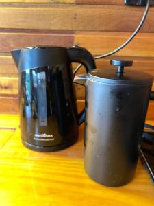 a black coffee pot sitting on top of a table at The Valley Cabin in Barracão