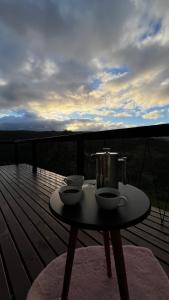 a table on a deck with two bowls on it at The Valley Cabin in Alfredo Wagner +37 photos