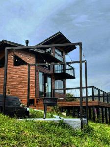 a wooden house with a porch and a deck at The Valley Cabin in Barracão