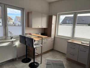 uma pequena cozinha com uma secretária e 2 janelas em Wohnung 6 Toni em Oedt