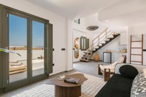 a living room with a couch and a staircase at Acro Caldo Suites in Akrotiri +85 photos