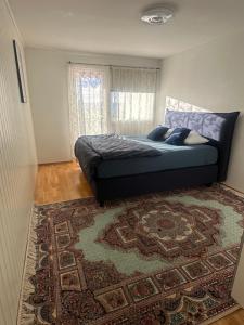 a bedroom with a bed with a rug and a window at Cozy place in Lutvann in Oslo