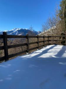 a fence covered in snow with mountains in the background at Chalet Gure Xokoa à Melles in La Celle-sous-Gouzon