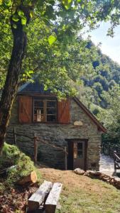 a stone cabin with a bench in front of it at Chalet Gure Xokoa à Melles in La Celle-sous-Gouzon