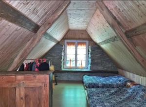 a attic room with two beds and a window at Chalet Gure Xokoa à Melles in La Celle-sous-Gouzon