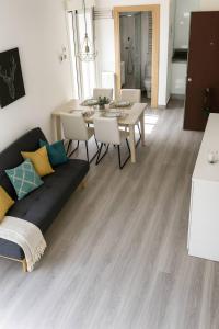 a living room with a couch and a dining table at MODERNO NUEVO Luminoso WI-FI PLAZA DEL PILAR 2 in Zaragoza