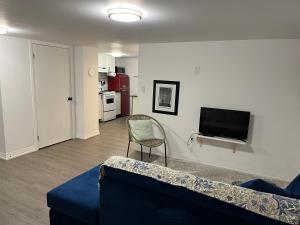 a living room with a couch and a television at Merritt Place Niagara in St. Catharines