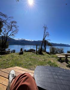 a person sitting on a picnic table with a snowboard at Costa Traful in Villa Traful