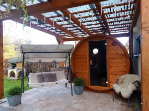 a pergola over a patio with a bed and a couch at Apartmán Paula -blízko Tatralandie a Bešeňovej in Liptovský Mikuláš
