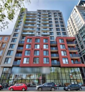 a tall building with cars parked in front of it at The Downtown Oasis in Montréal
