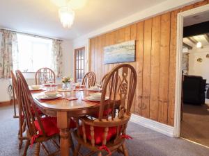 a dining room with a wooden table and chairs at Bryn Re in Trawsfynydd