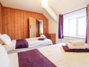 a bedroom with two beds and a window at Bryn Re in Trawsfynydd