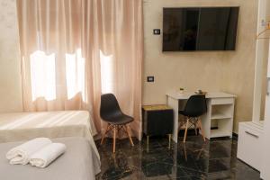 ein Hotelzimmer mit zwei Betten, einem Tisch und Stühlen in der Unterkunft BeB Imperial in Catanzaro