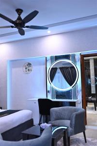 a living room with a ceiling fan and a mirror at Signature Boutique Hotel Karachi in Karachi