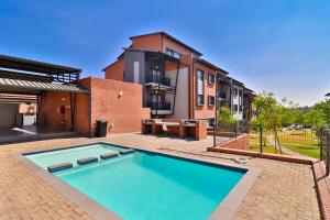 a swimming pool in front of a building at Waterfall Smart Apartment 2bed2bath in Midrand