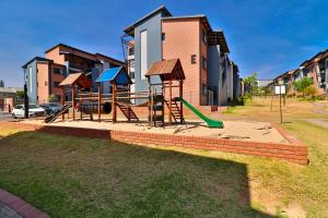 a playground with a slide and a swing set at Waterfall Smart Apartment 2bed2bath in Midrand