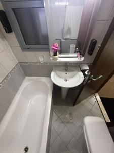 ein Badezimmer mit Badewanne, Toilette und Waschbecken in der Unterkunft Suite one bedroom in Abu Dhabi