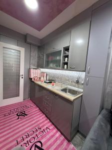 a kitchen with a pink rug on the floor at Analadyboss in Leskovac