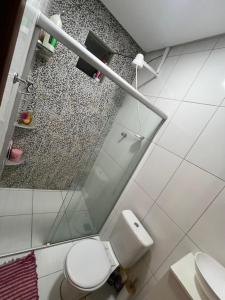 een badkamer met toilet en glazen douche bij Residência 02 in Japaratinga