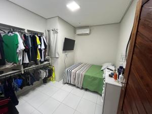 een kleine kamer met een bed en een kast bij Residência 02 in Japaratinga